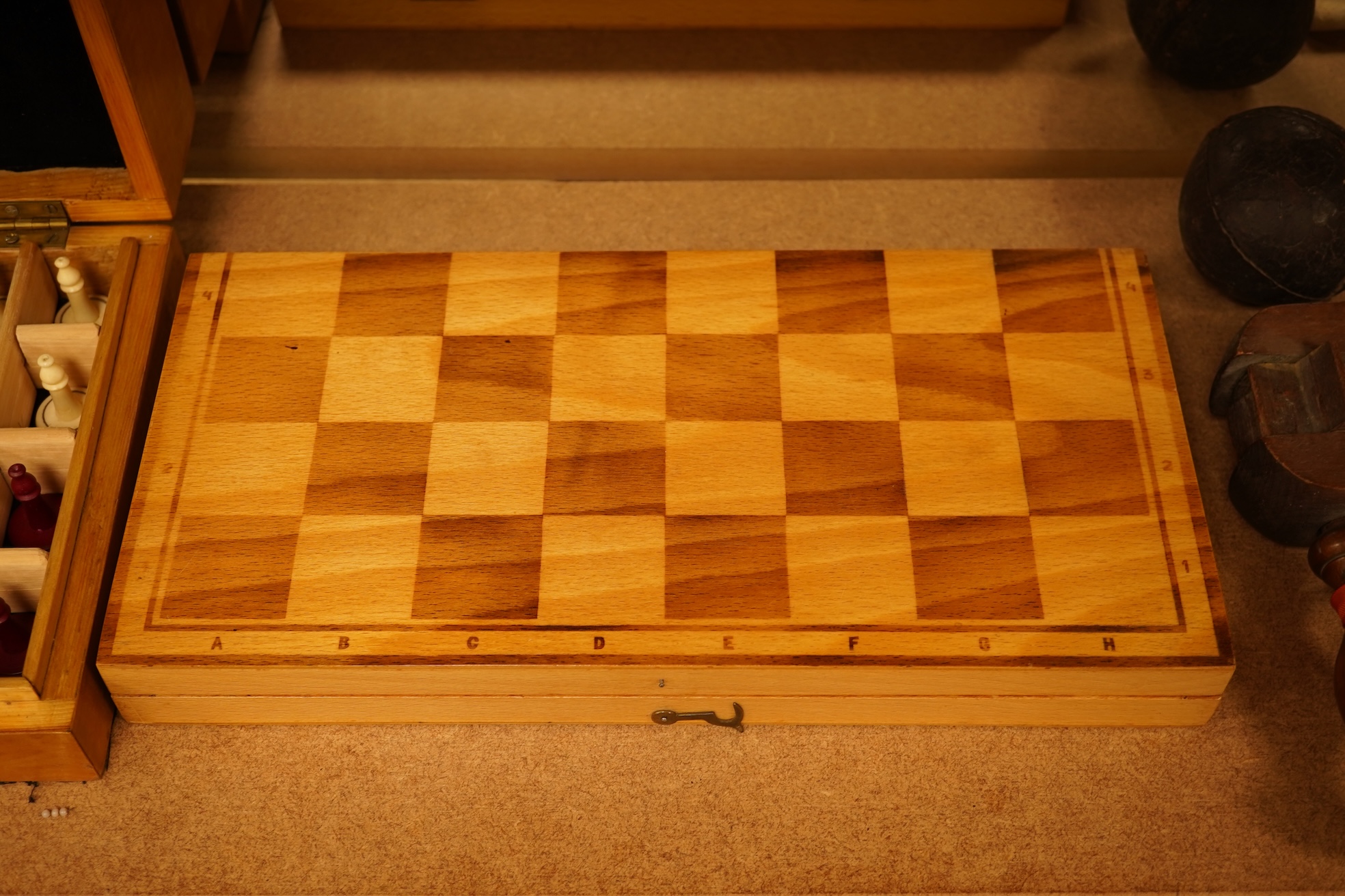 Two boxed chess sets, a cricket ball and a bird scaring rattle, largest chess set 32cm wide x 9cm high x 20cm deep.